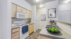 Flagstaff apartment for rent - A kitchen with a white stove and wooden cabinets.