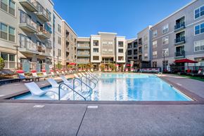 Nashville apartment for rent - Apartment complex swimming pool with lounge chairs and umbrellas.