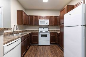 Addis apartment for rent - Sugar Mill Apartments in Addis, LA photo of a kitchen with white appliances and wooden cabinets