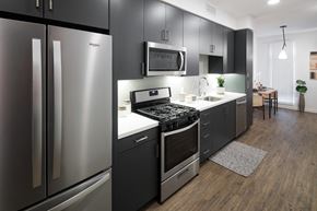 Oakland apartment for rent - a kitchen with black cabinets and a stainless steel refrigerator