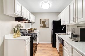 Stone Mountain apartment for rent - Affinitee at Stone Mountain Apartments photo of an open kitchen with white cabinets and a black refrigerator