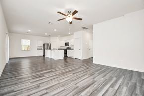 Houston apartment for rent - A spacious room with a ceiling fan and wooden flooring.