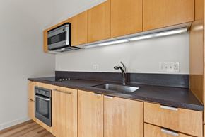 Portland apartment for rent - A kitchen with wooden cabinets and a black countertop.