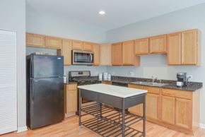 Chicago apartment for rent - a kitchen with a stainless steel island and a black refrigerator