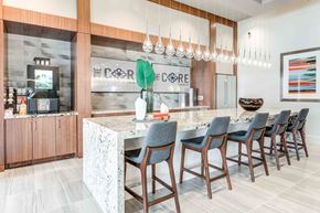 Chandler apartment for rent - Apartments for Rent Chandler, AZ - The Core Chandler - Clubhouse Community Kitchen with Spacious Quartz Countertop Island, Bar Seating, Refrigerator, Coffee Station, Brown Cabinetry, and Overhead Hanging Light Bulbs.