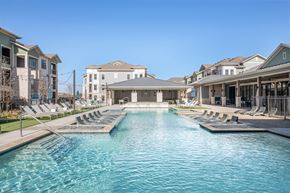 Midland apartment for rent - a swimming pool with lounge chairs in front of a building
