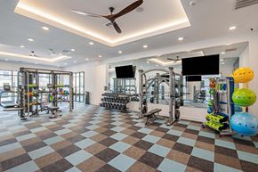 Midland apartment for rent - a gym with weights and cardio machines and a ceiling fan