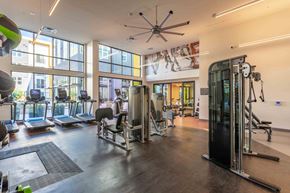 San Jose apartment for rent - A gym with a variety of equipment including treadmills, weights, and a fan.