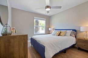 Tempe apartment for rent - A bedroom with a bed, nightstand, and a mirror on the wall.