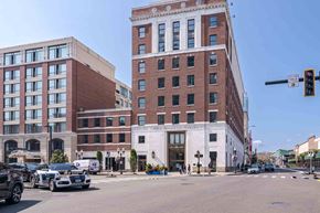 Stamford apartment for rent - The One Atlantic apartment building with a red brick exterior and white lower level on a sunny city street.