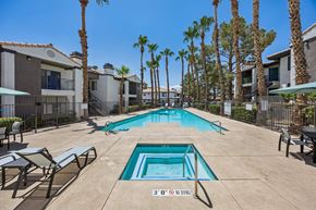 Henderson apartment for rent - A pool surrounded by palm trees and lounge chairs.
