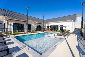 New Braunfels apartment for rent - A pool area with a building in the background.