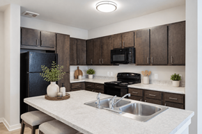 Clarkston apartment for rent - Professionally staged kitchen with breakfast bar at Townes at Clarkston Centre apartments in Clarkston, GA.