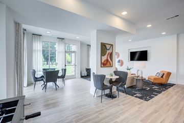 Clarkston apartment for rent - A living room with a grey sofa, a black chair and a white table.