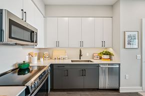 Raleigh apartment for rent - A modern kitchen with a green stove top and white cabinets.