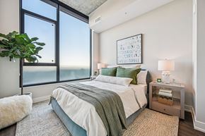 Raleigh apartment for rent - A bedroom with a large bed and a view of the ocean.