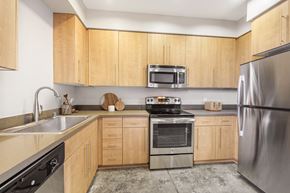 Long Beach apartment for rent - 2 Bedroom Modern Apartments in Long Beach, CA - Urban Village - Kitchen with Stained Concrete Flooring, Light Wood Cabinetry, Stainless Steel Appliances, and Quartz Countertops.