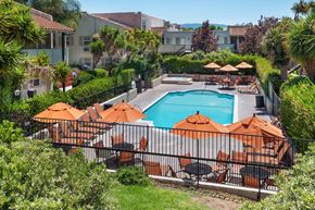 San Jose apartment for rent - Dog-Friendly Apartments in San Jose, CA - Village of Taxco - Swimming Pool With Lounge Seating, Orange Umbrellas, Spa Area, Lush Landscaping, And Apartment Buildings.