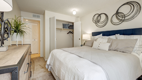 Denver apartment for rent - A bedroom with a large bed and a white wall.