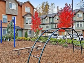 Kenmore apartment for rent - Kenmore WA Apartments - Northshore Townhomes - Outdoor Playground with Metal Bars, Swings, and Surrounding Trees