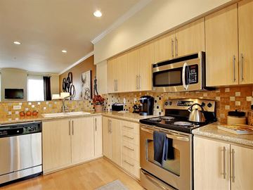 Kenmore apartment for rent - a kitchen with stainless steel appliances and wooden cabinets