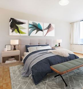 Washington apartment for rent - A bedroom with a large bed and a bench in front of it.