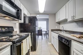 Harvey apartment for rent - Westchase Apartments in Harvey LA photo of a kitchen with white cabinets and black appliances and a black refrigerator