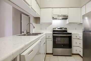 Kerrville apartment for rent - A kitchen with white cabinets and stainless steel appliances.