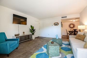 Orlando apartment for rent - A living room with a blue chair and a white couch.