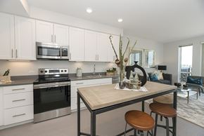 Oakland apartment for rent - A modern kitchen with a wooden table and bar stools.