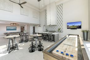 Oakland apartment for rent - A shiny pool table with blue balls numbered 1-5 is in the middle of a room with a TV on the wall.