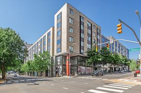 Raleigh apartment for rent - A street view of a multi-story building with a traffic light in front of it.