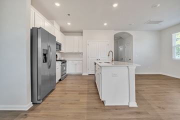 Taylors apartment for rent - A modern kitchen with white cabinets and a wooden floor.