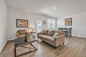Taylors apartment for rent - Living room with tan sofa, armchair, and dining table.