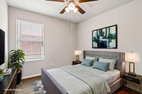 Conroe apartment for rent - A bedroom with a bed, nightstands, and a ceiling fan.