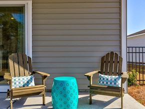 Myrtle Beach triplex for rent - Houses for Rent in Myrtle Beach, SC - The Palmer at Carolina Forest - Spacious Private Patio With a Fenced Yard, Two Wooden Armchairs, and a Blue Side Table