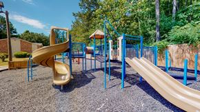 Augusta apartment for rent - Community playground at Broad on the Green in Augusta, Georgia featuring slides and swings for outdoor recreation.