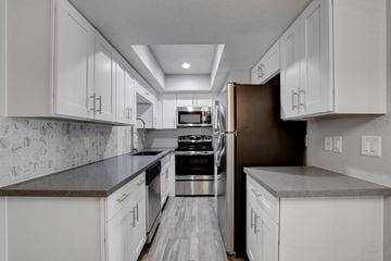 Henderson apartment for rent - A kitchen with white cabinets and a black stove top oven.