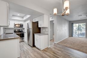 Henderson apartment for rent - A modern kitchen with white cabinets and a wooden floor.