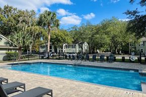 Gainesville apartment for rent - Community swimming pool with lounge seating at Chelsea Apartments in Gainesville FL