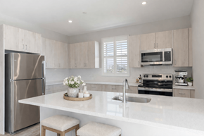 Fairfield apartment for rent - Open-concept kitchen featuring quartz-style countertops, large island seating area, and stainless steel appliances at Creekline at Fairfield apartments, Fairfield CT.