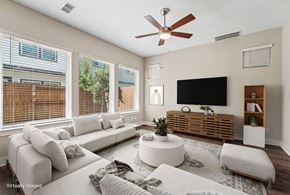 Houston townhouse for rent - A living room with a white couch, a flat screen TV, and a ceiling fan.