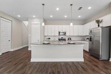 Houston townhouse for rent - A modern kitchen with white cabinets and a central island.