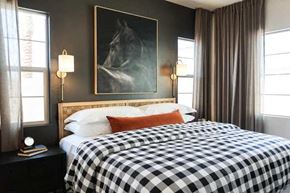 Apache Junction apartment for rent - A bedroom with a black and white checkered bedspread and a painting of a horse on the wall.