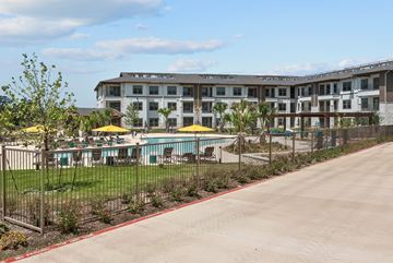 Universal City apartment for rent - A large building with a pool in front of it.