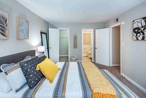 Raleigh apartment for rent - A bedroom with a bed and a striped runner on the floor.