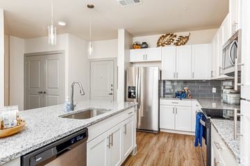 Saginaw apartment for rent - a kitchen with white cabinets and a stainless steel refrigerator