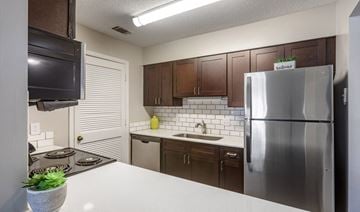 Peachtree City apartment for rent - A kitchen with a stove top oven and a refrigerator.