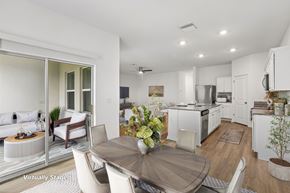 Zephyrhills apartment for rent - A modern kitchen with white cabinets and a dining table set for two.