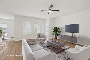 Zephyrhills apartment for rent - A living room with a grey couch, a chair, a coffee table, and a television.